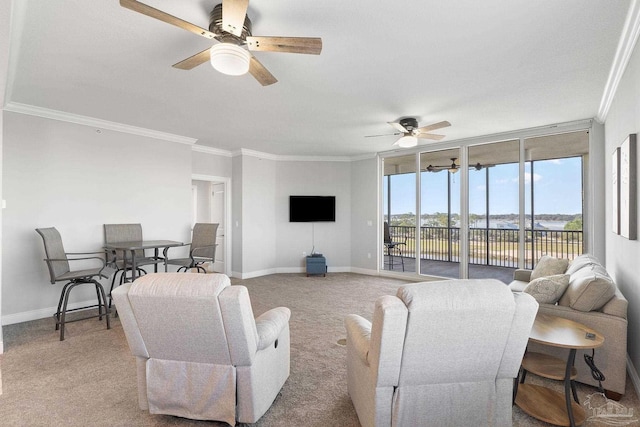 living room featuring baseboards, ornamental molding, a ceiling fan, and light colored carpet