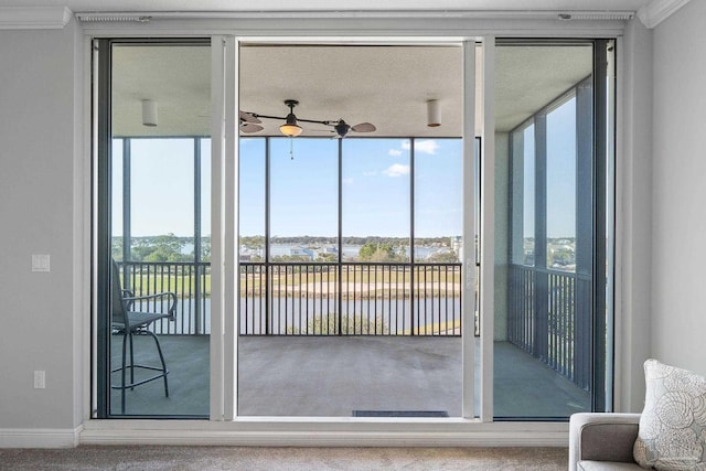 doorway to outside with a water view, plenty of natural light, and a wall of windows