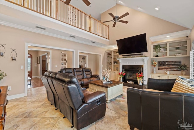 living room featuring ceiling fan, ornamental molding, built in features, and a towering ceiling