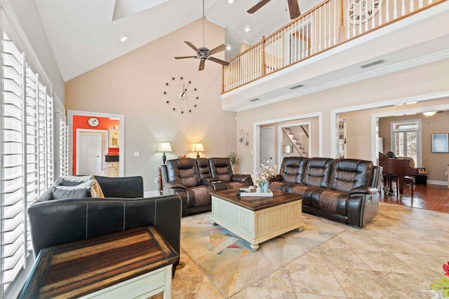 living room featuring ceiling fan and a towering ceiling