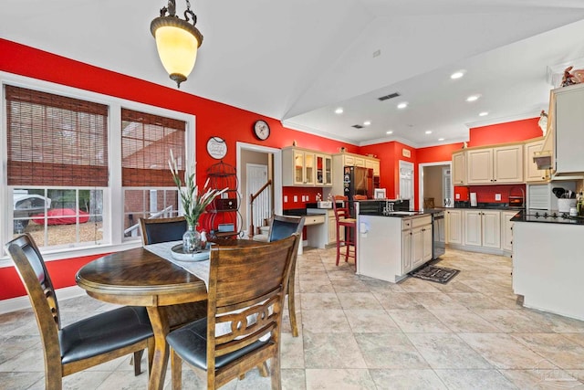 dining room with ornamental molding and vaulted ceiling