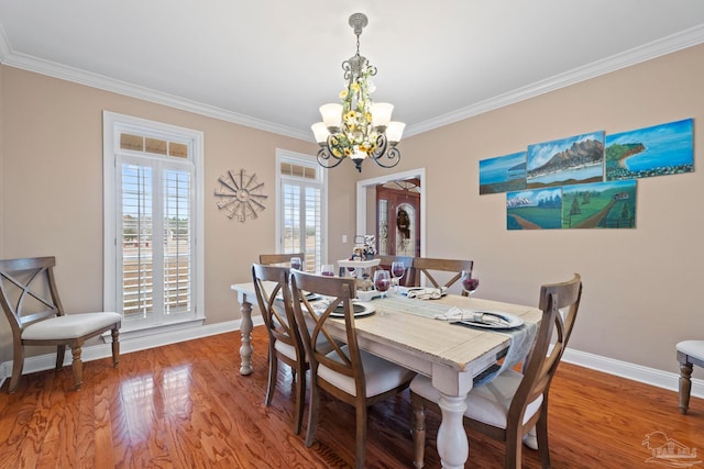 dining area featuring hardwood / wood-style flooring, crown molding, and a chandelier