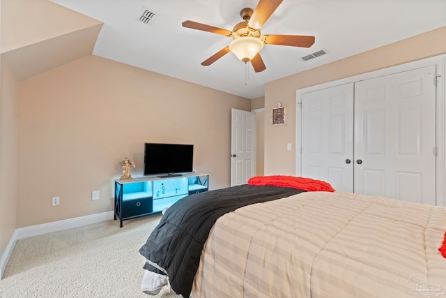 carpeted bedroom with ceiling fan, lofted ceiling, and a closet