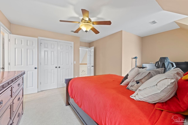 carpeted bedroom featuring ceiling fan and a closet