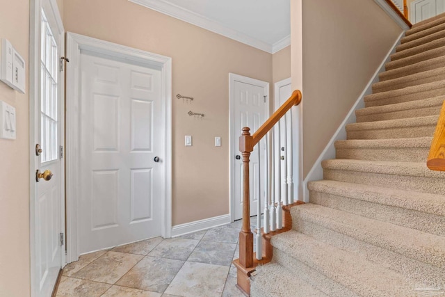 tiled foyer entrance featuring ornamental molding