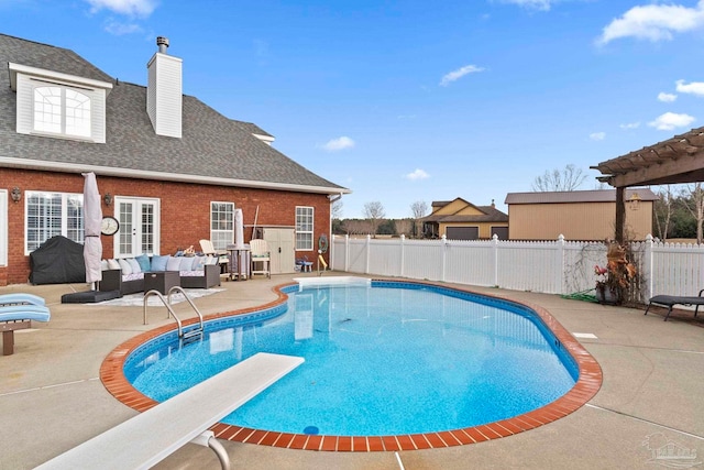 view of swimming pool featuring outdoor lounge area, a diving board, and a patio area