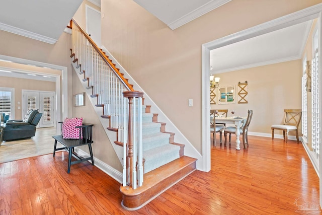 staircase featuring hardwood / wood-style floors, ornamental molding, and french doors