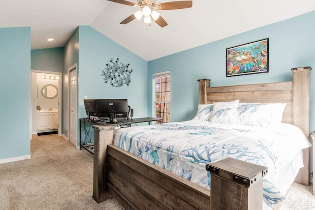 bedroom with ceiling fan, ensuite bath, a closet, light colored carpet, and vaulted ceiling