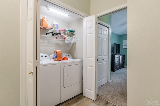 washroom with washer and clothes dryer and light wood-type flooring