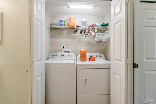 clothes washing area featuring independent washer and dryer and a textured ceiling