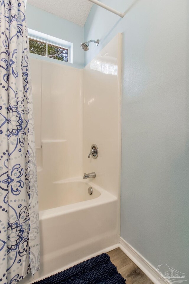 bathroom with shower / tub combo and hardwood / wood-style floors