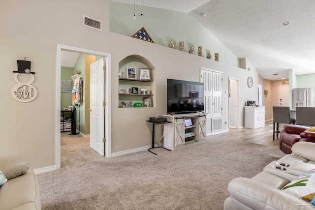 living room featuring light carpet, a textured ceiling, built in features, and high vaulted ceiling