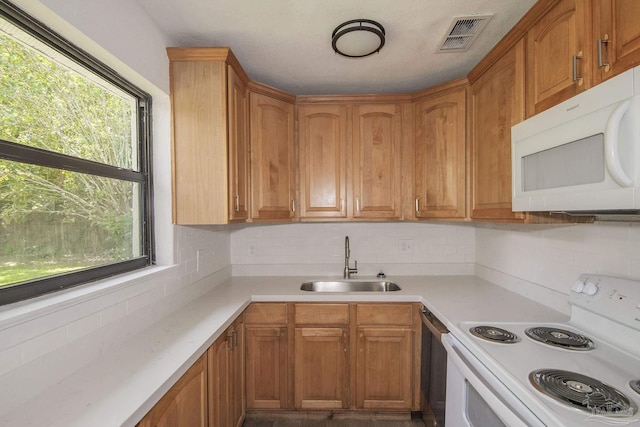 60 Stanford Rd, Pensacola, FL 32506 - kitchen featuring white appliances, visible vents, a sink, light countertops, and backsplash