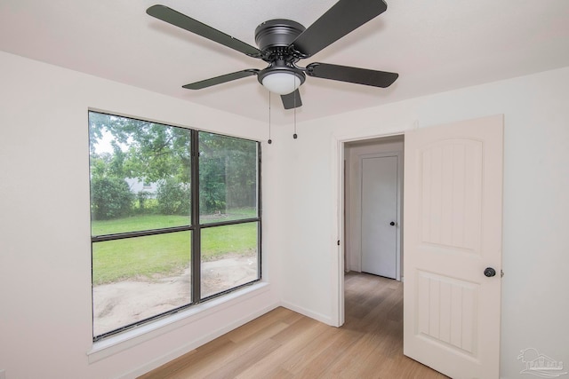 spare room with ceiling fan and light wood-type flooring