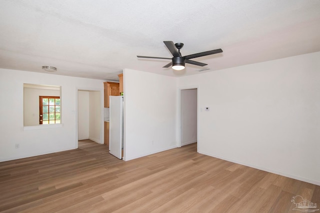 interior space with white fridge, ceiling fan, and light hardwood / wood-style floors