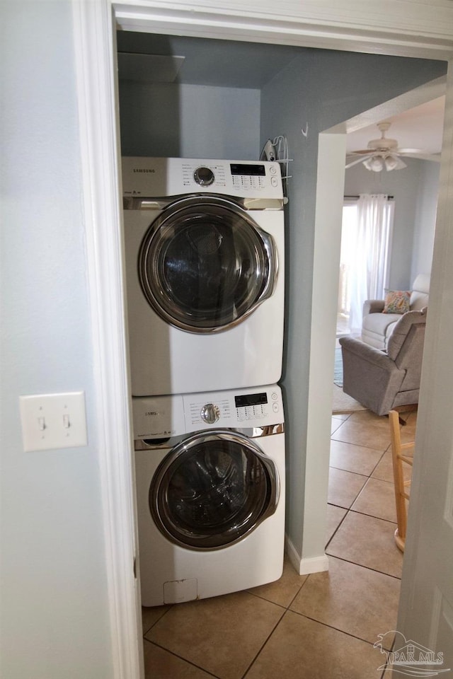 laundry room featuring ceiling fan, tile patterned flooring, and stacked washer and dryer