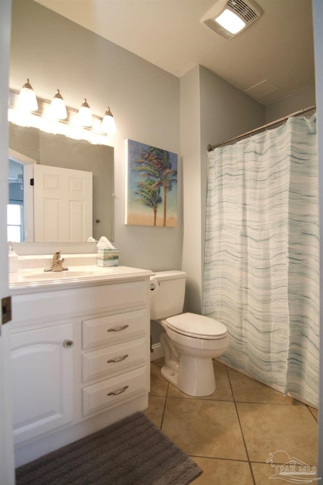 bathroom with toilet, vanity, tile patterned floors, and a shower with curtain