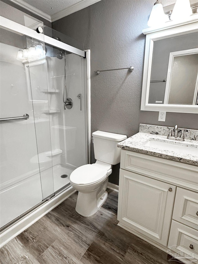 6910 Cornelius Ln, Pensacola, FL 32505 - bathroom featuring a stall shower, vanity, wood finished floors, a textured wall, and ornamental molding