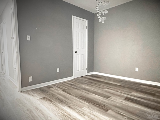 6910 Cornelius Ln, Pensacola, FL 32505 - spare room featuring wood finished floors and a chandelier