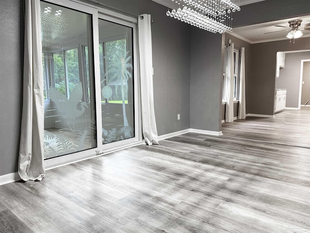6910 Cornelius Ln, Pensacola, FL 32505 - spare room featuring crown molding, a chandelier, wood finished floors, and a ceiling fan
