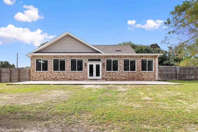 rear view of property featuring a yard, a patio area, and french doors