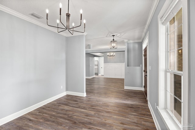 unfurnished dining area featuring a textured ceiling, crown molding, dark wood-type flooring, and a notable chandelier