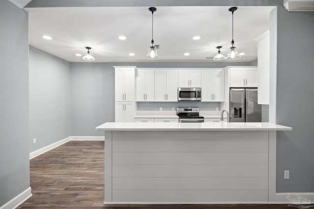 kitchen featuring white cabinetry, stainless steel appliances, dark hardwood / wood-style flooring, kitchen peninsula, and decorative light fixtures