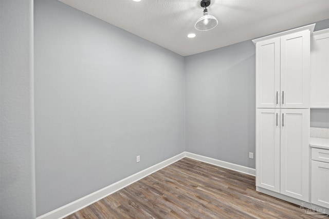 empty room with dark hardwood / wood-style flooring and a textured ceiling