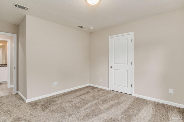 spare room featuring light colored carpet