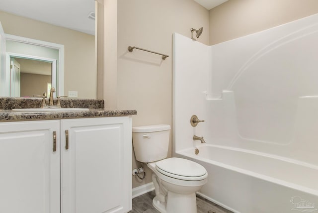 full bathroom with hardwood / wood-style flooring, vanity,  shower combination, and toilet