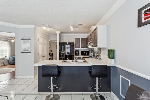 kitchen with a kitchen bar, black refrigerator with ice dispenser, and kitchen peninsula