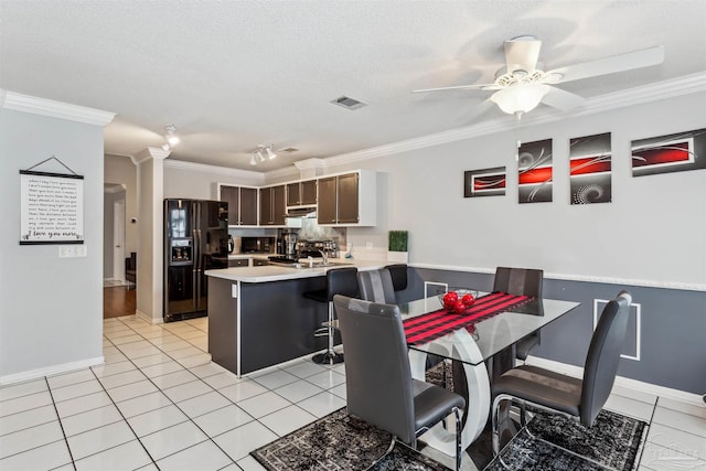 dining area with ceiling fan, a textured ceiling, light tile patterned floors, and crown molding