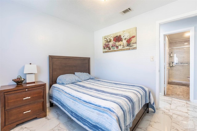 bedroom featuring ensuite bath and a textured ceiling