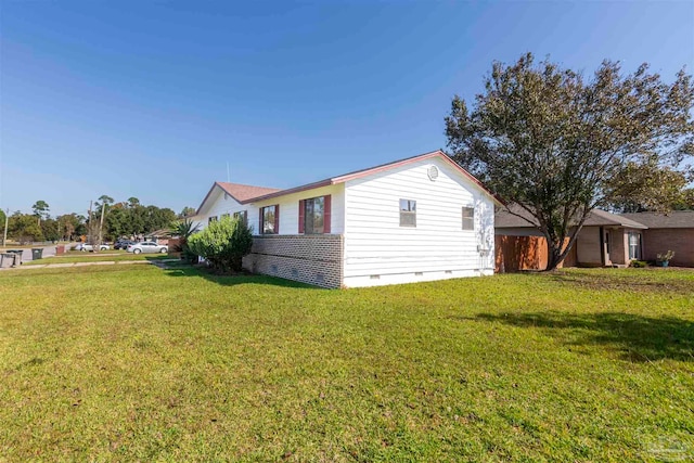 view of side of home with a yard