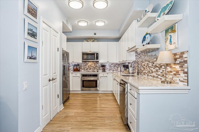 13599 Perdido Key Dr Unit T-2C, Perdido Key, FL 32507 - kitchen with appliances with stainless steel finishes, light wood-type flooring, decorative backsplash, and white cabinetry