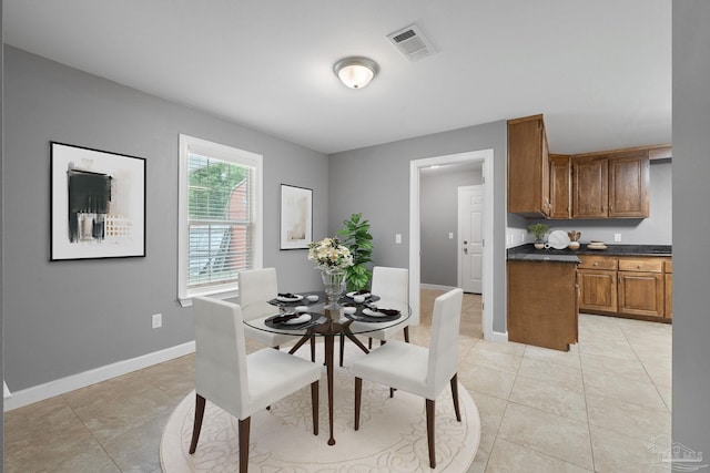 dining area with light tile patterned floors, baseboards, and visible vents