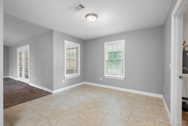 empty room featuring visible vents, baseboards, and tile patterned floors