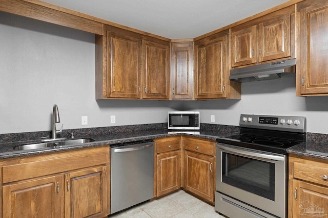kitchen featuring a sink, brown cabinetry, stainless steel appliances, and under cabinet range hood