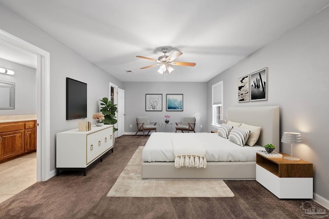 bedroom featuring baseboards, ensuite bathroom, dark colored carpet, and visible vents
