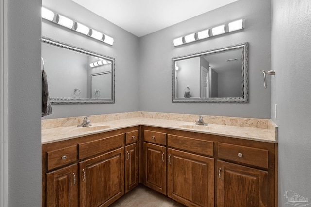full bathroom featuring double vanity, tile patterned floors, and a sink