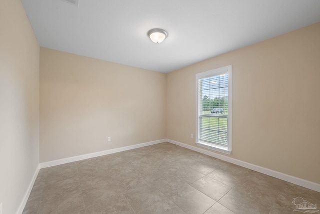 spare room with baseboards and tile patterned floors