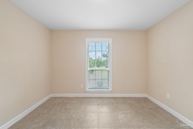 unfurnished room with baseboards and light tile patterned floors