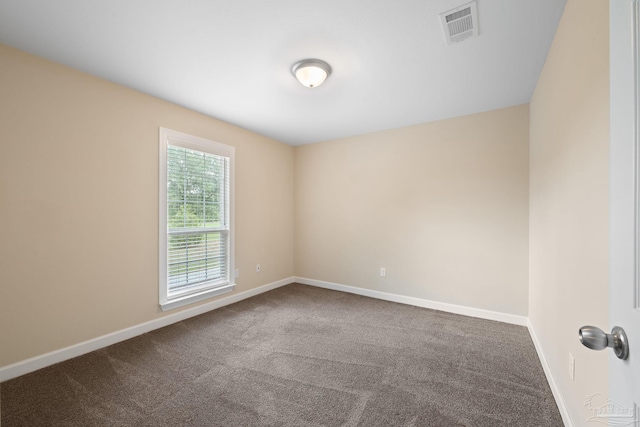 empty room featuring carpet floors, baseboards, and visible vents