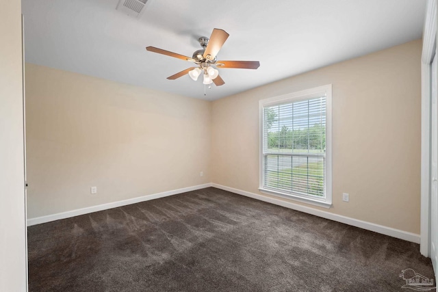 spare room featuring a ceiling fan, baseboards, visible vents, and dark colored carpet