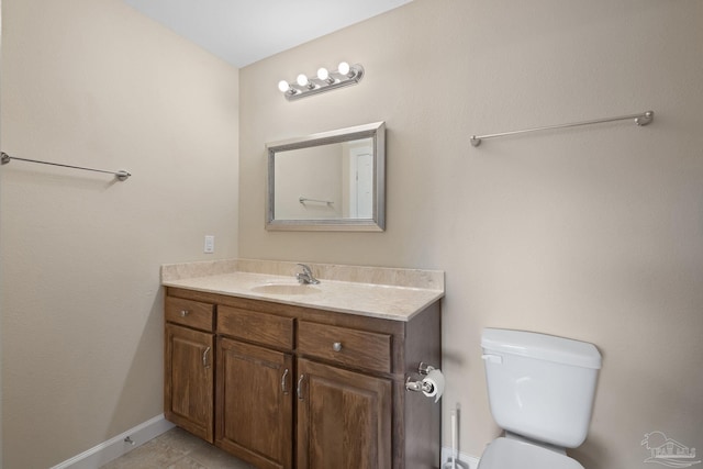 bathroom with vanity, tile patterned flooring, baseboards, and toilet