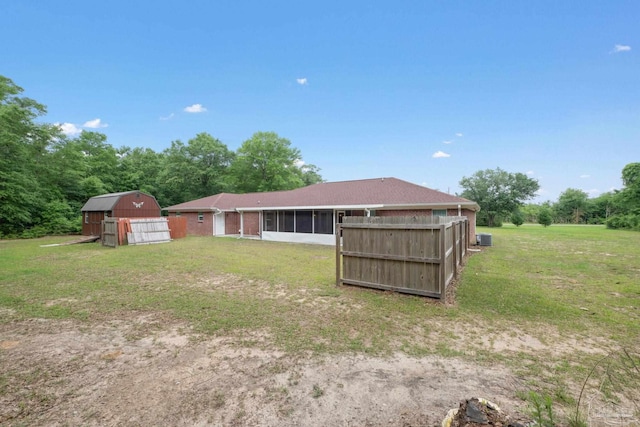 view of yard featuring a barn, an outdoor structure, and a sunroom