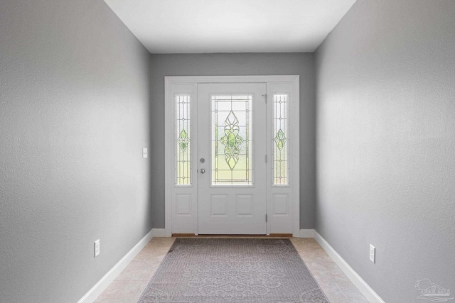 entrance foyer featuring plenty of natural light, a textured wall, and light tile patterned floors