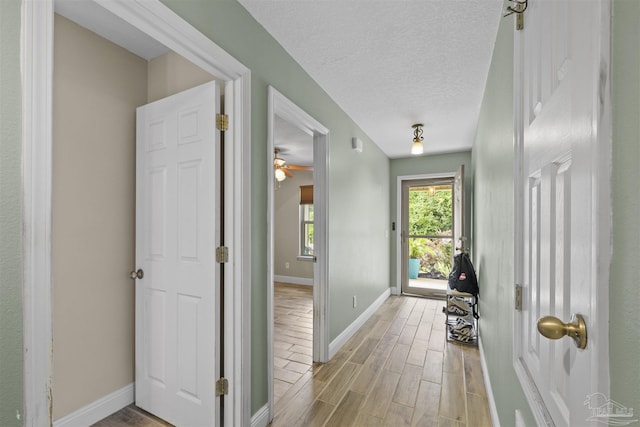 3963 Edgefield St, Pace, FL 32571 - hall featuring light wood-style flooring, baseboards, and a textured ceiling
