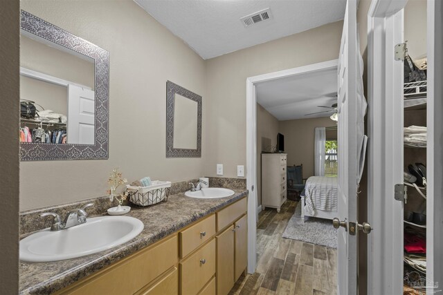 3963 Edgefield St, Pace, FL 32571 - ensuite bathroom featuring a spacious closet, double vanity, wood finished floors, and a ceiling fan