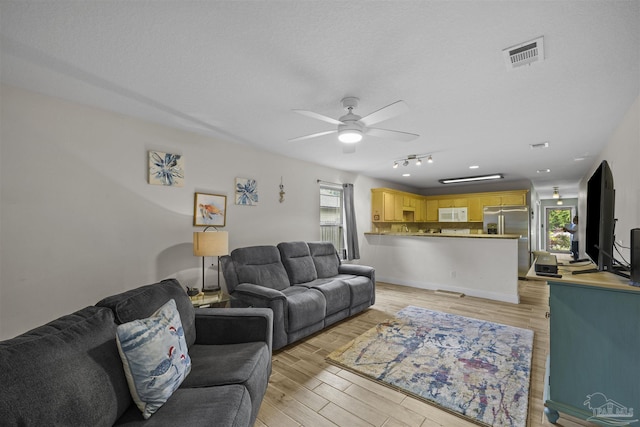 3963 Edgefield St, Pace, FL 32571 - living room with ceiling fan, light wood finished floors, and a textured ceiling